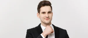 Smiling thoughtful man touching his chin while considering men's health and wellness solutions against a white background.