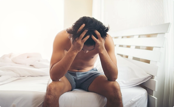 worried man sitting in bed