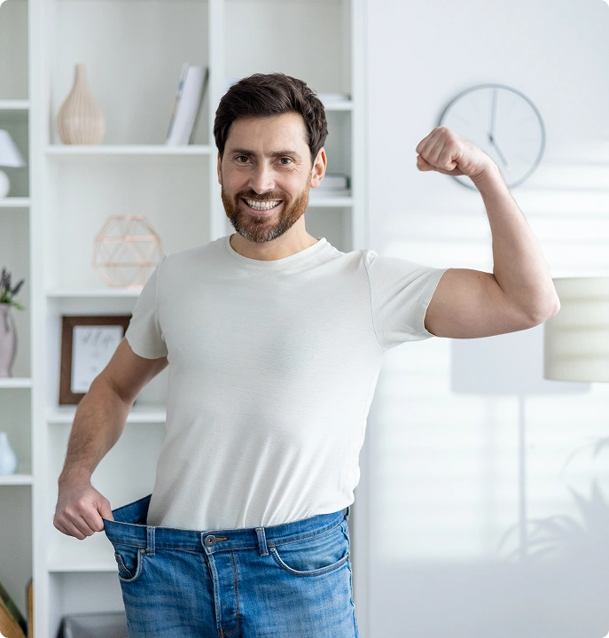 Happy man with loose jeans after weight loss